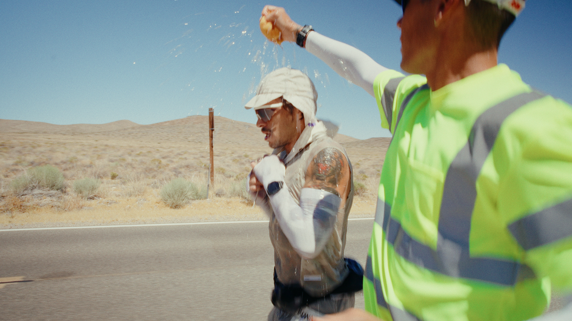 a man pouring cold water over a runner