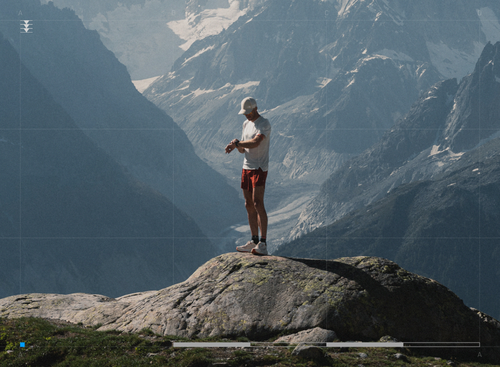a man standing on a cliff looking at his watch