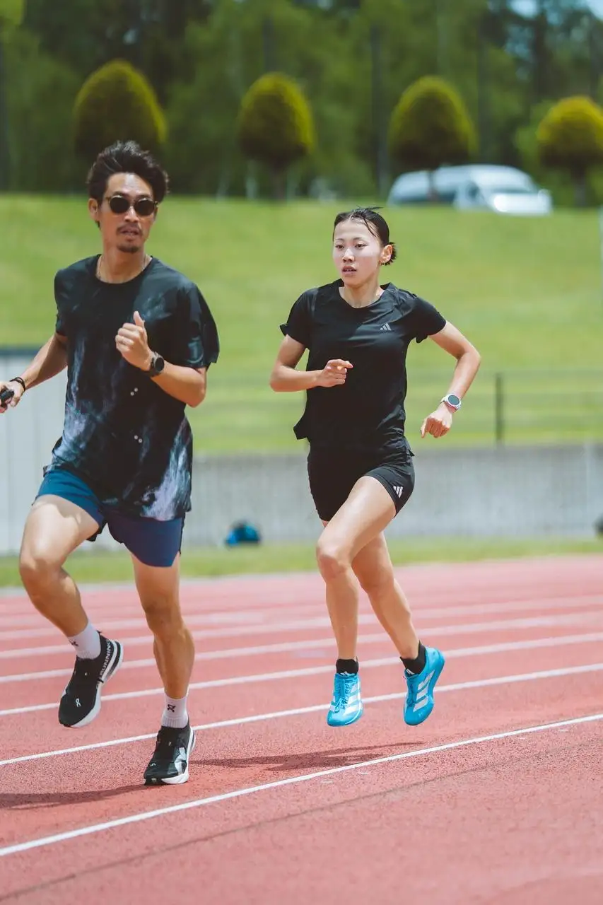 陸上トラックを走る男性と女性